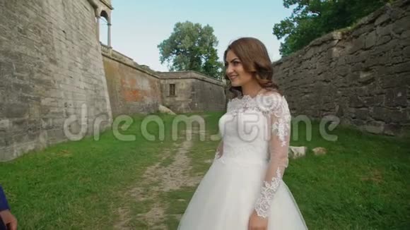 可爱的新婚夫妇互相拥抱在城堡附近慢慢地视频的预览图