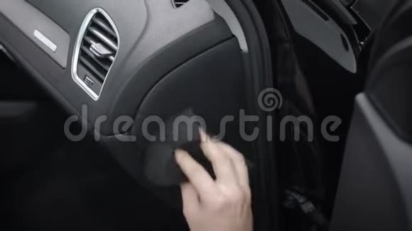 男人正在清洗汽车内部的控制面板用软布摩擦它清除灰尘和污垢特写镜头视频的预览图