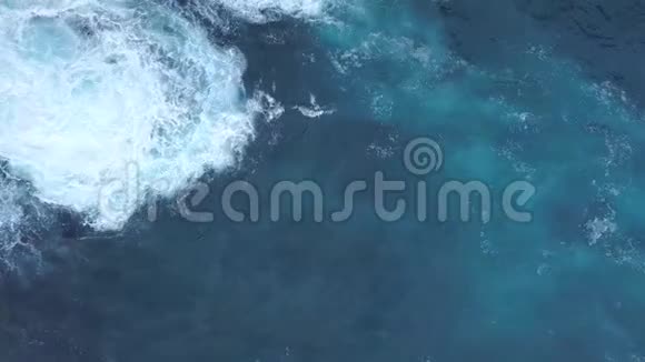 大蓝海波的空中无人机射击使热带岛屿海岸悬崖上的白沫和撞击4K视频的预览图