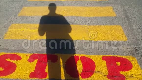 一个人站在行人过路处的开头在那里停下来等待经过的时间在黄色的视频的预览图