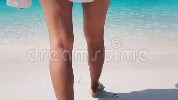 穿比基尼和衬衫的女人在海滩散步视频的预览图