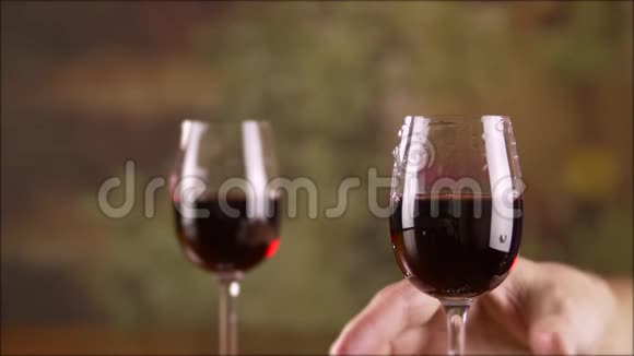 关闭男性手拿红酒杯搅拌慢动作视频的预览图