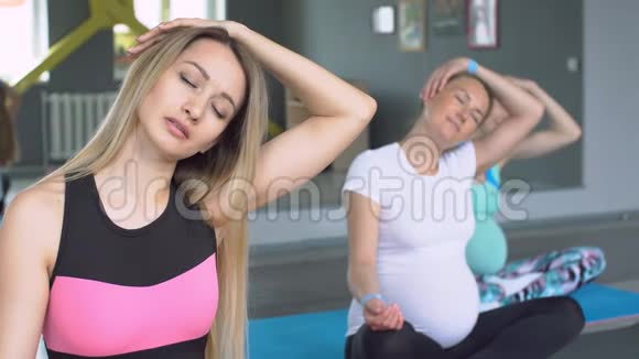 三名年轻孕妇练习瑜伽肖像视频的预览图