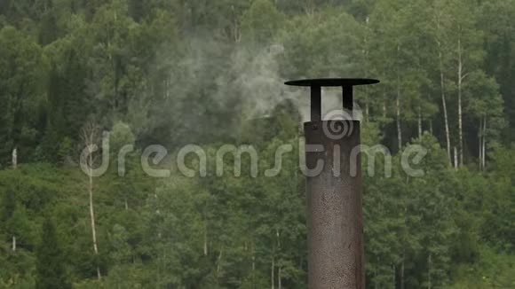 烟来自房子的铁烟烟雾堆积在树的背景上慢动作视频的预览图