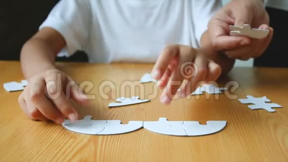 4K家的手爸爸妈妈孩子们在木桌上玩心形拼图视频的预览图