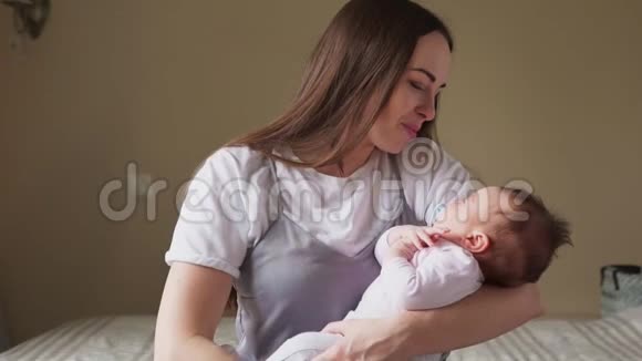 幸福的母亲抱着孩子轻轻地亲吻视频的预览图