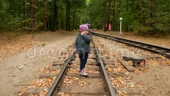 一个小女孩走在铁轨上视频的预览图