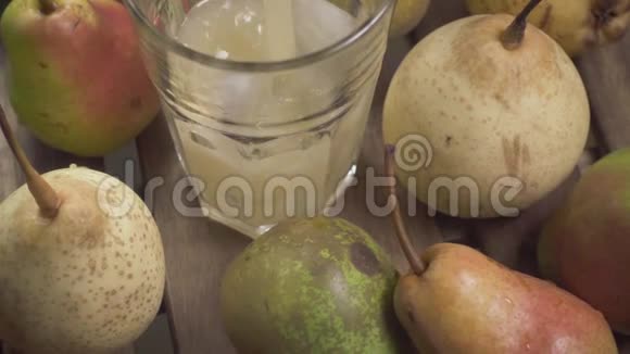 慢动作的果汁倒入一个装有冰块的玻璃杯中放入梨视频的预览图