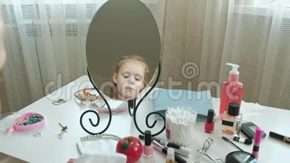 红头发的小女孩照镜子用湿巾清洁面部皮肤化妆面部时尚风格视频的预览图