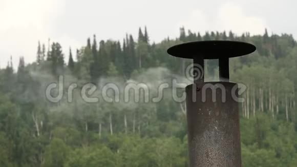 烟来自房子的铁烟烟雾堆积在树的背景上慢动作视频的预览图