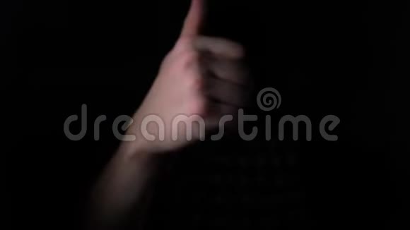 从黑暗中走出来的手势进入光线把拇指伸进摄像机4k慢动作视频的预览图