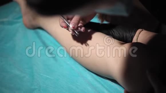 美容师用镊子从年轻女人的腿上取下头发视频的预览图