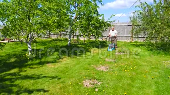 老人在美丽的花园里割草机视频的预览图
