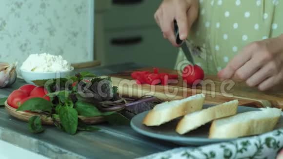 一个女人手的特写镜头是用面包奶酪和蔬菜为一个意大利的布鲁切塔准备的视频的预览图