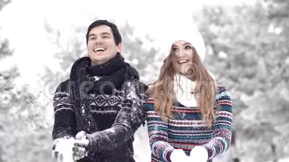 慢动作快乐夫妇玩雪把雪扔到空中视频的预览图