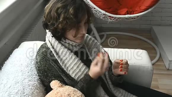 一个穿毛衣的病妇把药滴到鼻子里视频的预览图