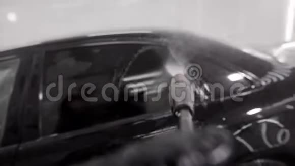 洗衣机正在用橡胶套把水倒在黑色汽车上用水喷射视频的预览图