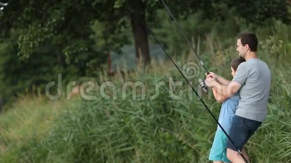 兴奋的儿子和父亲在池塘钓鱼视频的预览图
