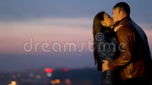 快乐的恋人拥抱在一个夜城的背景下视频的预览图