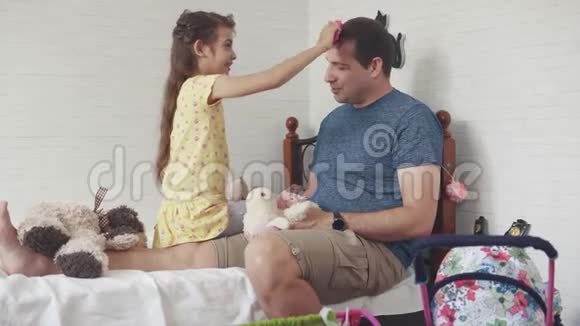一个小女孩用玩具梳子梳她爸爸父亲花时间陪女儿视频的预览图