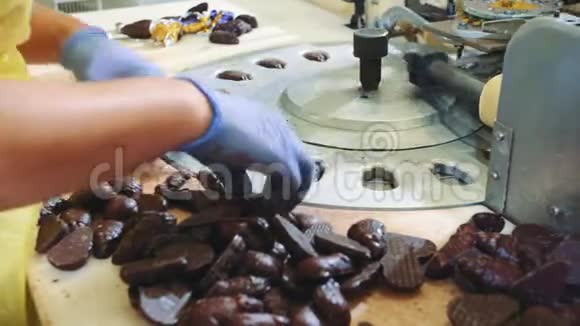 一群面目全非的女工把巧克力糖果放进糖果厂的包装机里视频的预览图