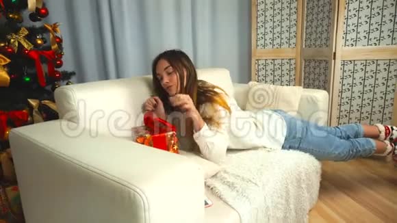 一个女孩在沙发上准备圣诞礼物视频的预览图