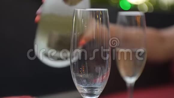 特写女性手将白起泡酒倒入杯中视频的预览图