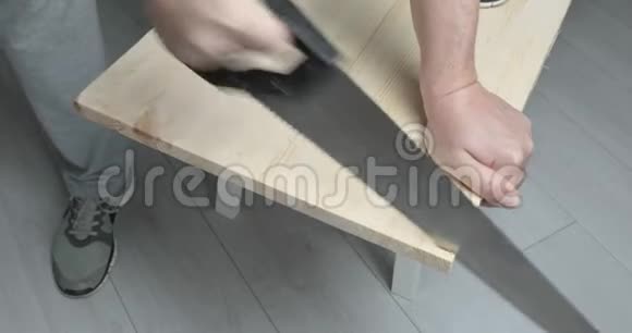 一个人用手锯锯木板视频的预览图