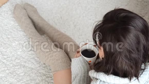 迷人的黑发少女端着咖啡坐在地毯上视频的预览图