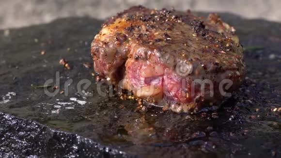 在户外野餐时用火烤肉用热在热石上用多汁的脂肪牛排烹饪香料视频的预览图
