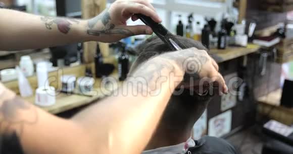 理发师用梳子和剪刀剪中年男子的短发视频的预览图