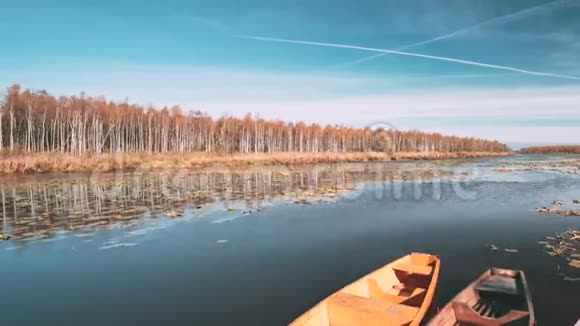 在美丽的秋日阳光明媚的日子里湖或河古老的划艇视频的预览图