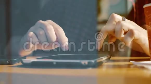 有人在咖啡厅的窗户里用平板电脑喝咖啡视频的预览图