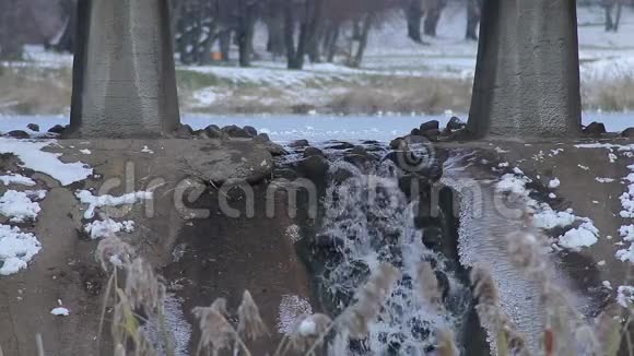 冬天湖底的桥下小瀑布视频的预览图