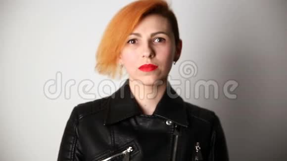 现代青年一位长相异常的严肃女人的平静肖像她的头发是红色的发型是有创意的穿着皮革视频的预览图