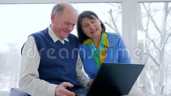 养老金领取者视频通信老年人在家里使用笔记本电脑在Skype上交谈视频的预览图