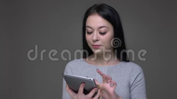 用平板电脑拍摄白种人年轻女性的特写镜头用绿色的彩色屏幕拍摄微笑视频的预览图