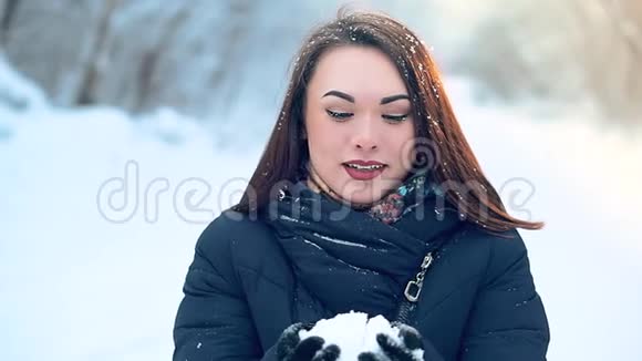 一个美丽的年轻女孩在寒冷的雪林中享受冬天的散步视频的预览图