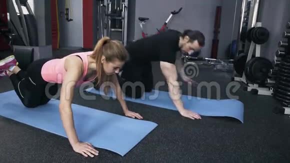 在健身房做俯卧撑的男人和女人视频的预览图