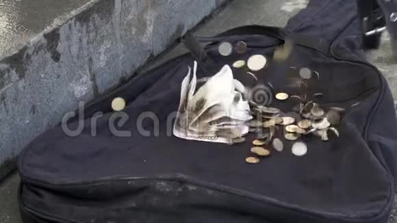 钱落在户外城市人行道上的黑色吉他箱上把纸币和硬币放在黑色空的视频的预览图