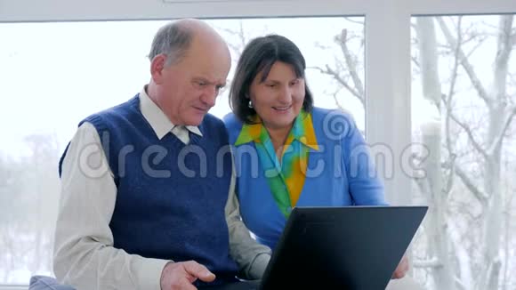 互联网技术年长夫妇在室内使用笔记本电脑在Skype上交谈视频的预览图