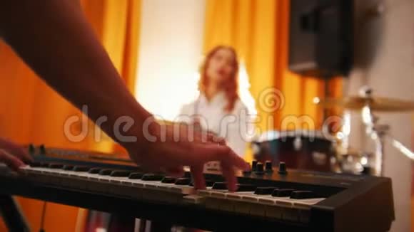 重复打鼓的女孩和键盘上的男人双手集中视频的预览图