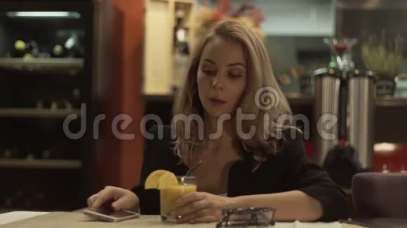 一位年轻女子通过鸡尾酒吸管喝橙汁视频的预览图