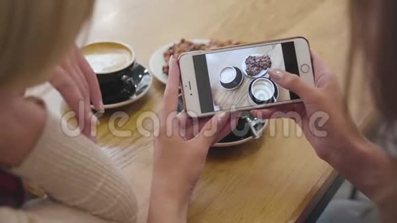 女子手拿食物拍照手机在咖啡厅特写视频的预览图