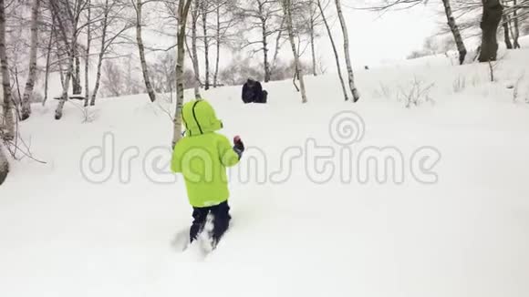 冬天跟着小孩子走到父亲身边在雪地里玩雪家人一起在户外玩视频的预览图