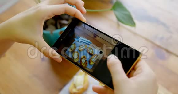 女士用手机拍摄零食托盘4k视频的预览图