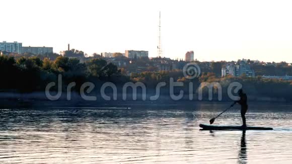 日落时分在苏台河上用桨划船的人剪影视频的预览图