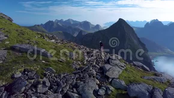 背着背包的女孩站在山脊上视频的预览图