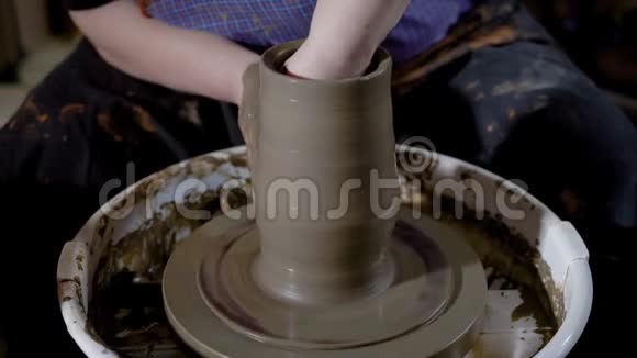 在一个生产车间的陶轮上用粘土将陶器主成形制成花瓶视频的预览图