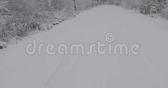 在大雪纷飞的冬日乡间小路上缓慢平稳的行驶视频的预览图
